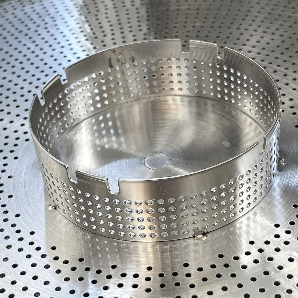 Grainfather G40 & G70 Hop Filter (Ny type) fra Grainfather er et sylindrisk metallfilter med perforerte sider som sitter på en perforert metalloverflate.