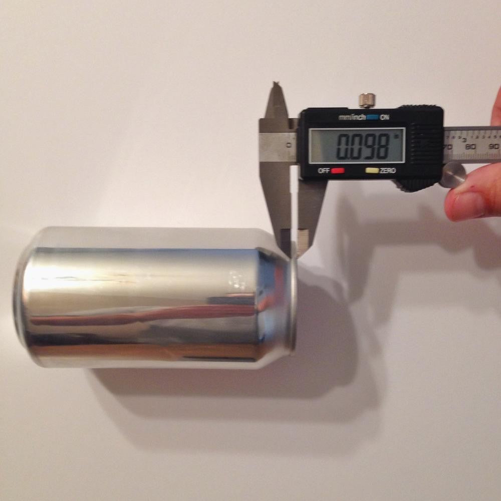 Oktober Design Digital Caliper - skyvelære måler diameteren på en metallboks og viser en avlesning på 0,981 tommer.
