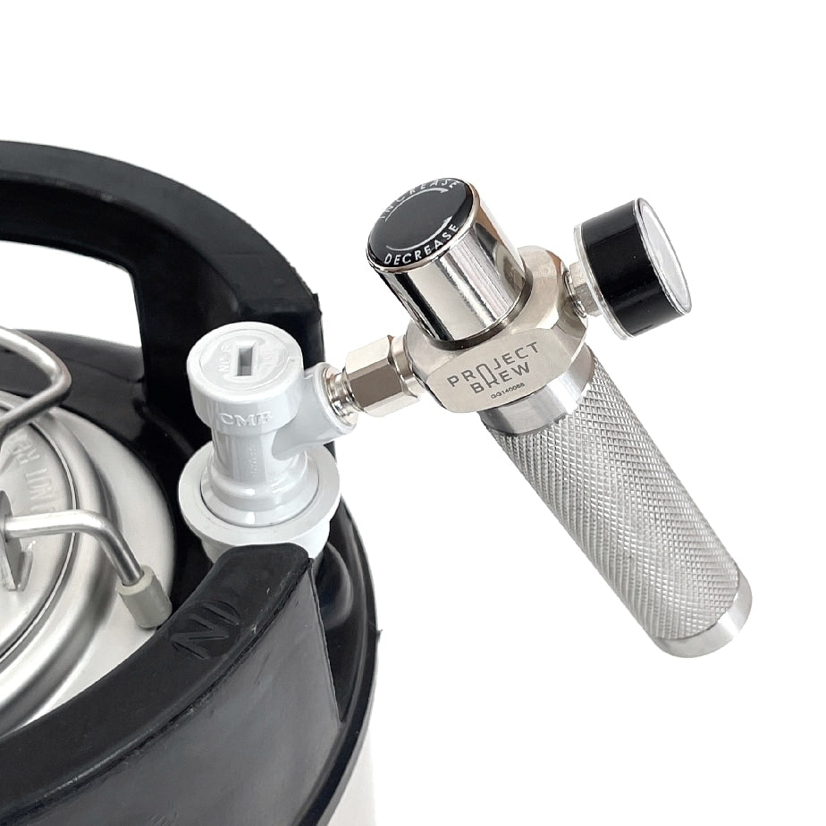 Nærbilde av Project Brew Beer Gas Mini Regulator fra Project Brew, laget av rustfritt stål, festet til et fat med en hurtigkobling av plast.