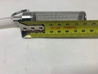 Et Keg King Dip tube-ølfilter, en metallsylinder med nøkkelring, ligger ved siden av en gul Stanley-tape som viser at det er ca. 70 mm langt.