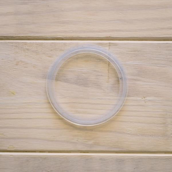 En 6" Tri-Clamp pakking silikon fra Brewshop ligger flatt på et lyst underlag av tre.