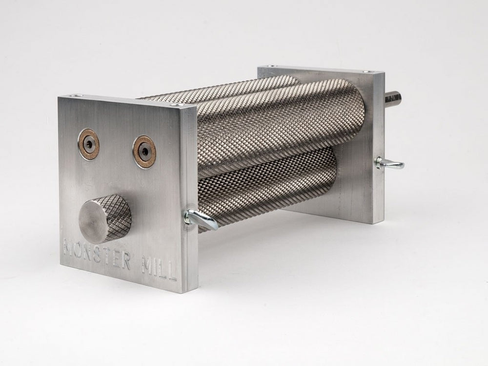 Monster Brewing Hardware Monster Mill MM-3, med base og trakt, har teksturerte valser i rustfritt stål og en rektangulær ramme - perfekt for hjemmebrygging. Møllen er vist mot en vanlig hvit bakgrunn.