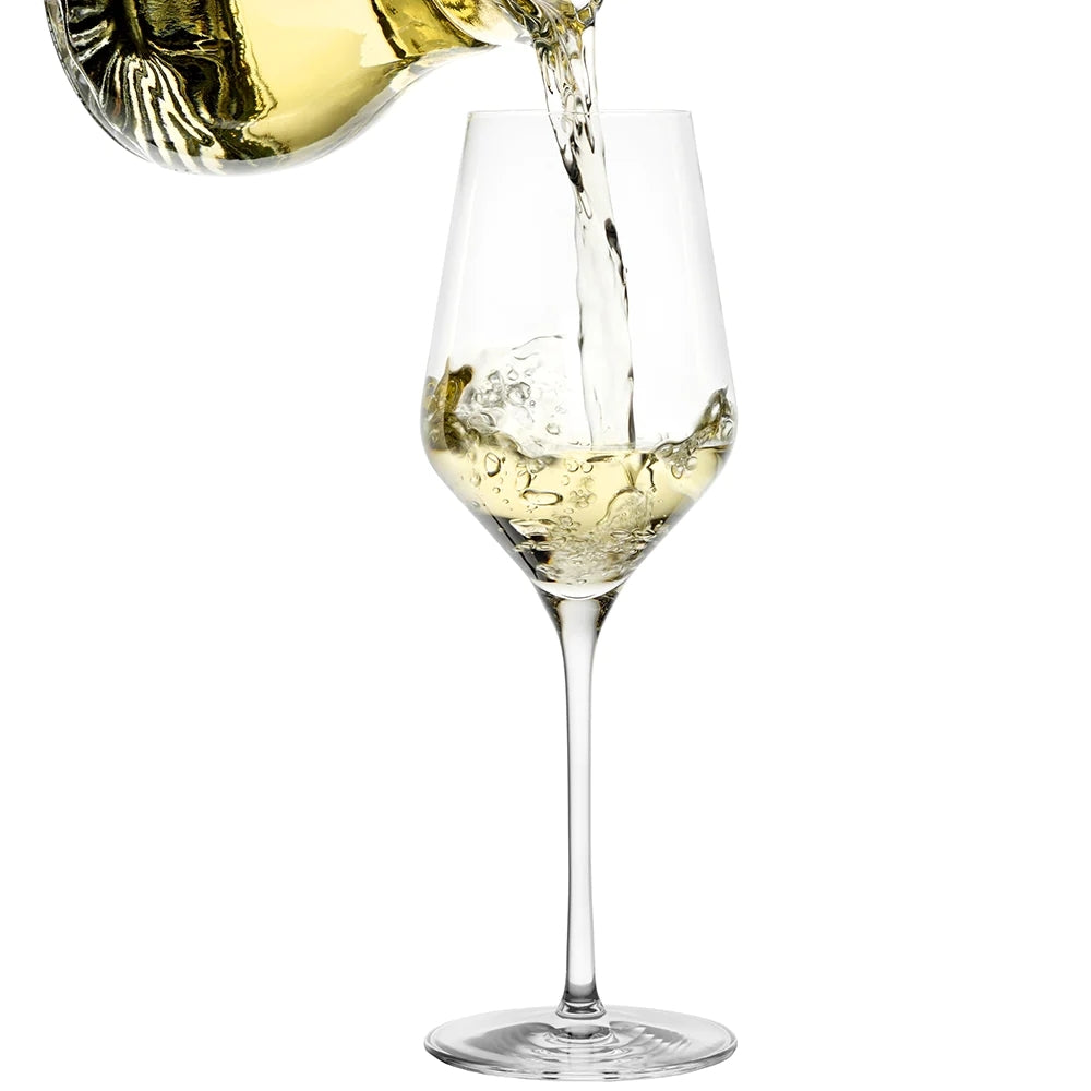 Hvitvin skjenkes i et QUATROPHIL White Wine vinglass 405 ml fra Stölzle Lausits, med et sett på 6 glass vist mot en hvit bakgrunn.