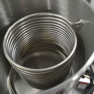 En Blichmann HERMS Coil Small, laget av rustfritt stål 304, plasseres i en metallgryte og fungerer som en vørterkjøler eller varmeveksler for brygging.