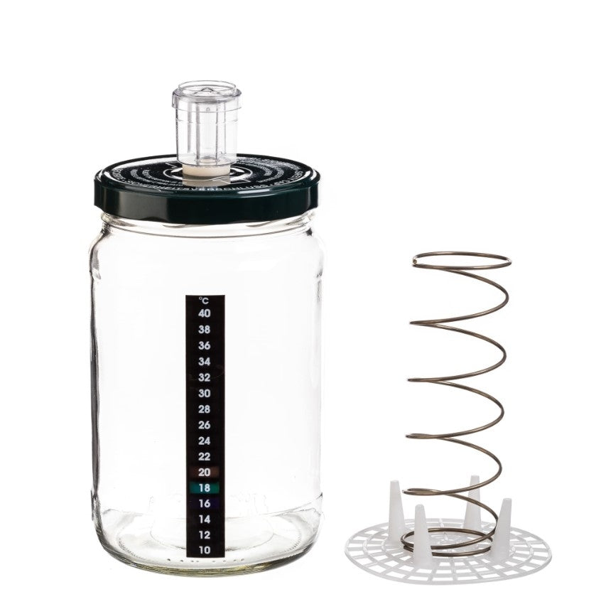 Enolandia 1,7L fermenteringsglass med presse og luftlås har svart lokk, temperaturstrip på siden og separat metallspiral med plastbase.