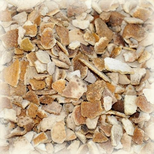 Nærbilde av tørkede, knuste, oransje og brune Appelsinskall søt-biter fra Castle Malting, spredt i en haug - perfekt til oppskrifter. Tilgjengelig i 5 kg bulkemballasje.