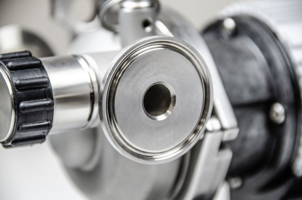 Nærbilde av en Blichmann Tri-Clamp RipTide Brewing Pump-fitting med sirkulær flens og sentral åpning, festet til utstyr - perfekt for presis hjemmebrygging. Merkevare: Blichmann.