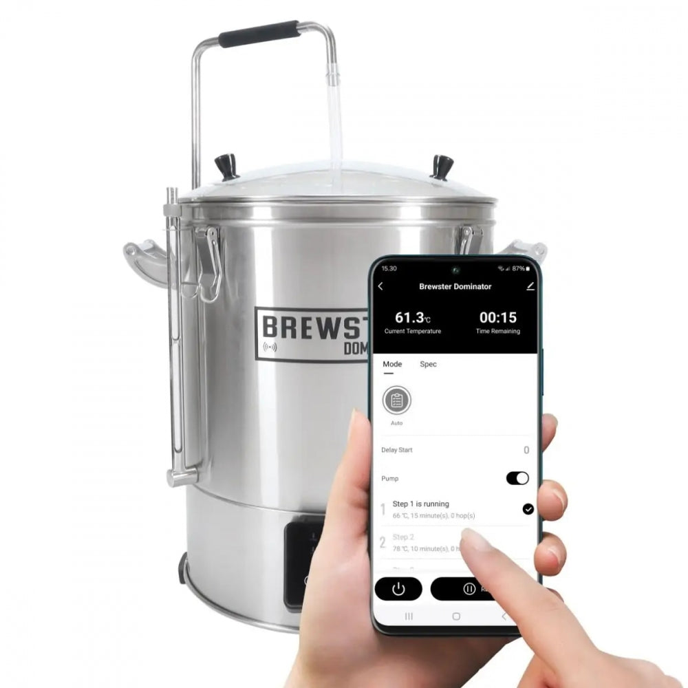 En person holder en smarttelefon som viser Brewster Dominator-appen foran Brewster Dominator 40 - WIFI Bryggemaskin fra Brewolution, ideell for enkel hjemmebrygging.