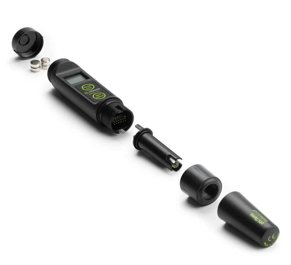 Milwaukee PH56 PRO vanntett pH-meter fra Milwaukee vises demontert, med hovedenhet, knapper og skjerm, batterier, utskiftbar probe og beskyttelseshetter pent lagt på rekke.