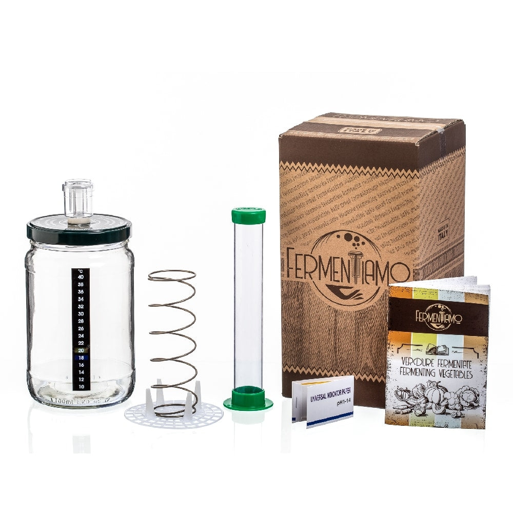 Sett for fermentering av grønnsaker fra Enolandia: inneholder fermenteringsglass, lokk, fjær, plastslange, eske, instruksjonshefte og ingredienspakke - alt du trenger for å starte med hjemmelaget fermentering. Alt vist på hvit bakgrunn.