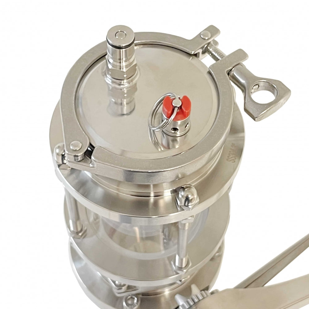 Project Brew Hop Dropper - Oksygenfri tørrhumling er en trykkbeholder i rustfritt stål og glass med tri-clamp skueglass, metallklemme, ventil og nøkkellignende håndtak; vist ovenfra.