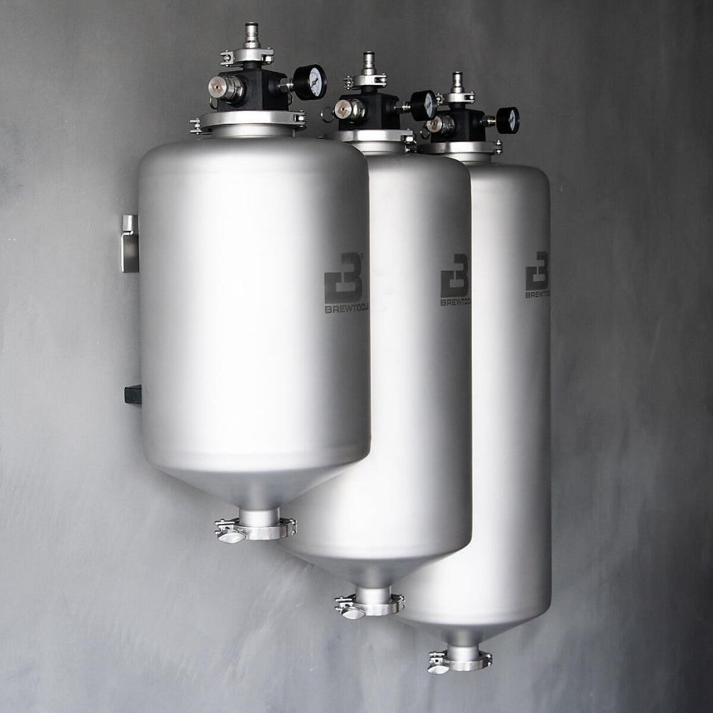 Tre Brewtools MiniUni 40-tanker med standardtilbehør er montert vertikalt på en grå vegg, perfekt for ølgjæring eller trykkgjæring.