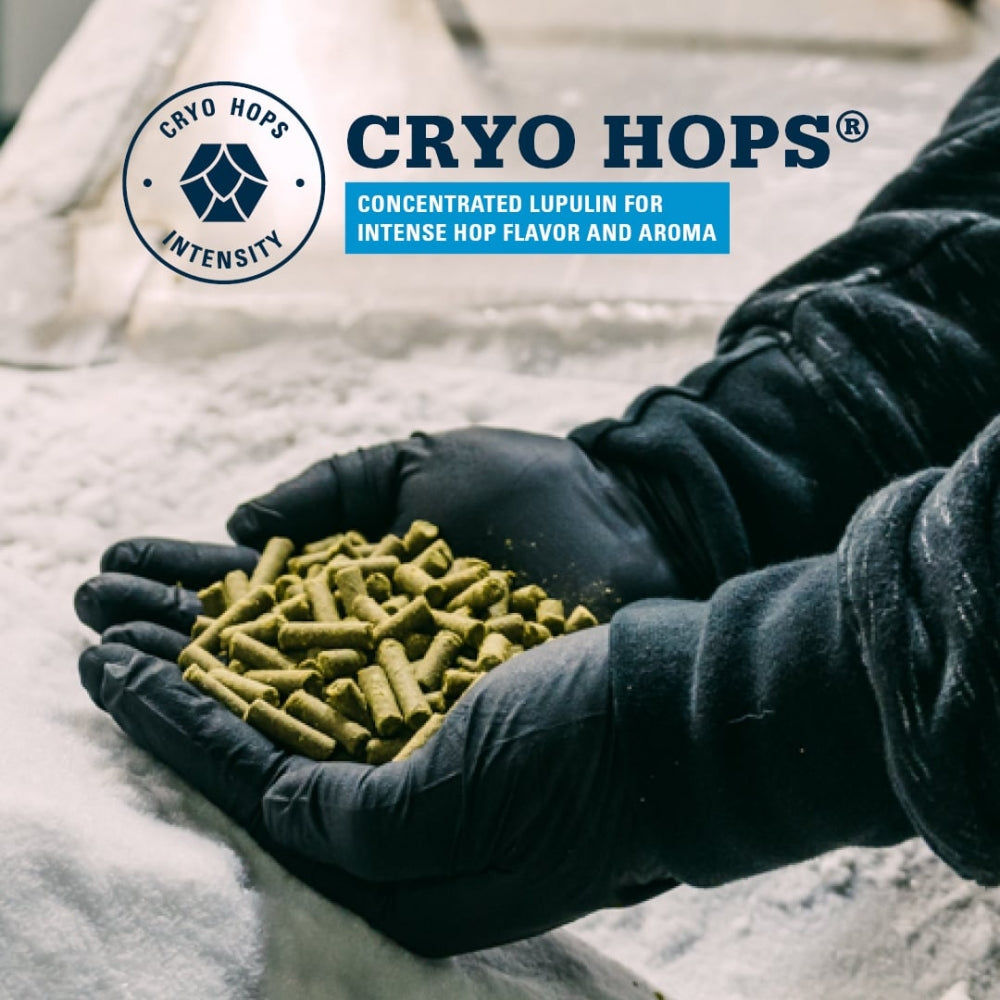 Hanskekledde hender holder grønne Mosaic 25 g Cryo Hops (21,3 %) pellets over en isete overflate, med Yakima Chief-merkevaren og produktbeskrivelsen for kryogen humlebehandling synlig i bakgrunnen.