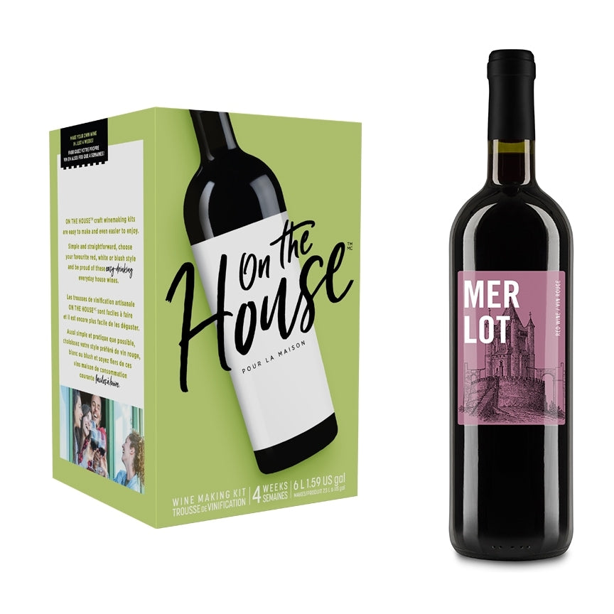 On The House Vinsett - Merlot Style fra On the House sitter ved siden av en rødvinsflaske i Merlot-stil med en bygningsillustrasjon på etiketten - ideell for alle som ønsker å lage vin hjemme.
