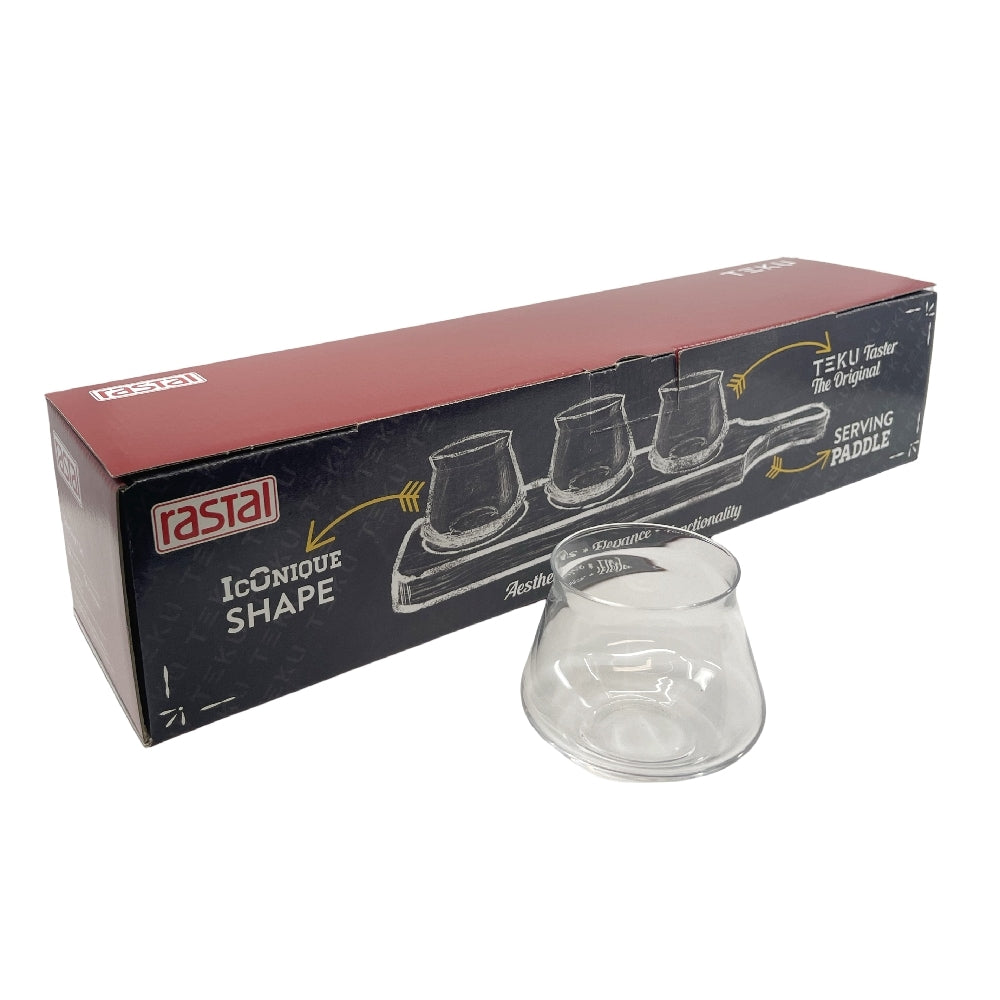 Her vises et Rastal Teku Taster Flight Set - smaksglass og smaksplanke fra Rastal, med et klart Teku Taster-glass foran en Iconique Shape-eske - ideelt for å smake øl på en smaksplanke.