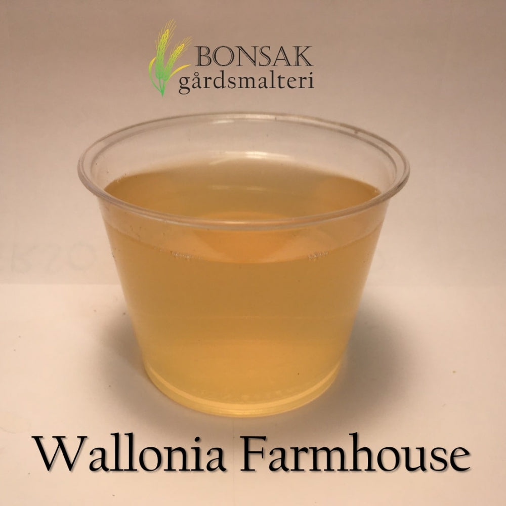 Et gjennomsiktig plastbeger med lysegul væske, merket Bonsak Gårdsmalteri Wallonia Farmhouse Malt (<3,3 EBC) 100G, fremhever den særegne smaken av denne malten.