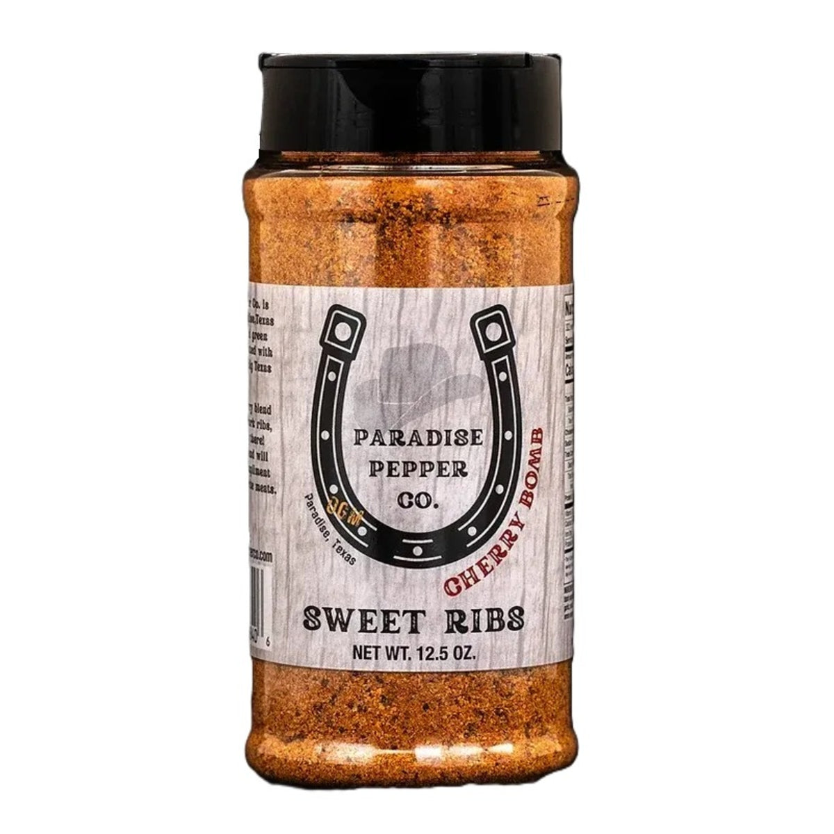 En beholder på 12,5 oz med «Paradise Pepper Co Cherry Bomb», en deilig krydderblanding med kirsebærsmak som er perfekt som grillkrydder eller svinekjøttkrydder, med et karakteristisk hestesko-logo på etiketten.