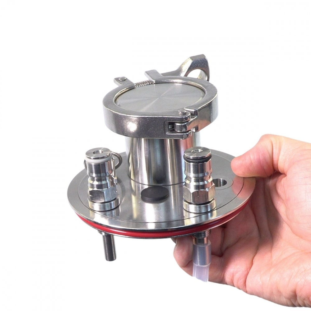 En hånd holder et Keg King Universal Apollo rustfritt ståltrykklokk i rustfritt stål - 2" Tri-Clamp, med påmonterte gass- og væskestolper, en trykkavlastningsventil og slangetilkobling.