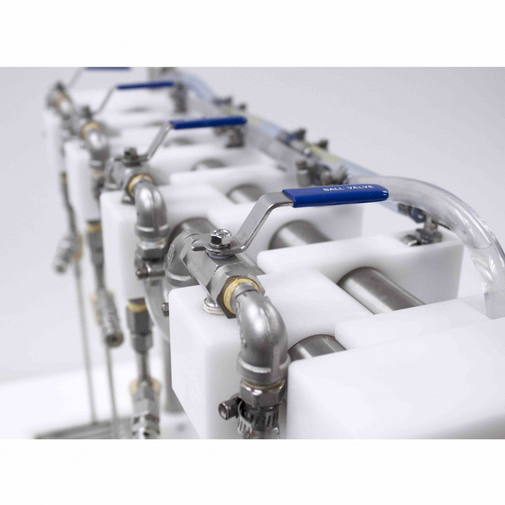 Nærbilde av Micro Filling Systems - Mottrykksfyller med 4 hoder: industrielle metallrør og ventiler med blått håndtak på hvite plaststøtter, perfekt for hjemmebryggere som bruker dette utstyret for karbonert øl.