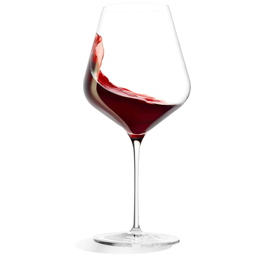 Et STARlight Burgunder vinglass 820 ml fra Stölzle Lausits fylt med virvlende rødvin som danner en bølge langs kanten.