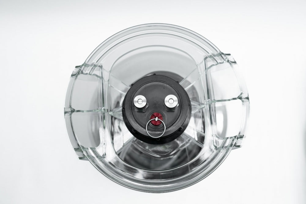 Oversiktsbilde ovenfra og ned av en tom glassblender med metallblader og en svart spindel i bunnen, som ligner på designet i Keg King Fermenter King Junior 10L Trykktank & Keg-systemet.