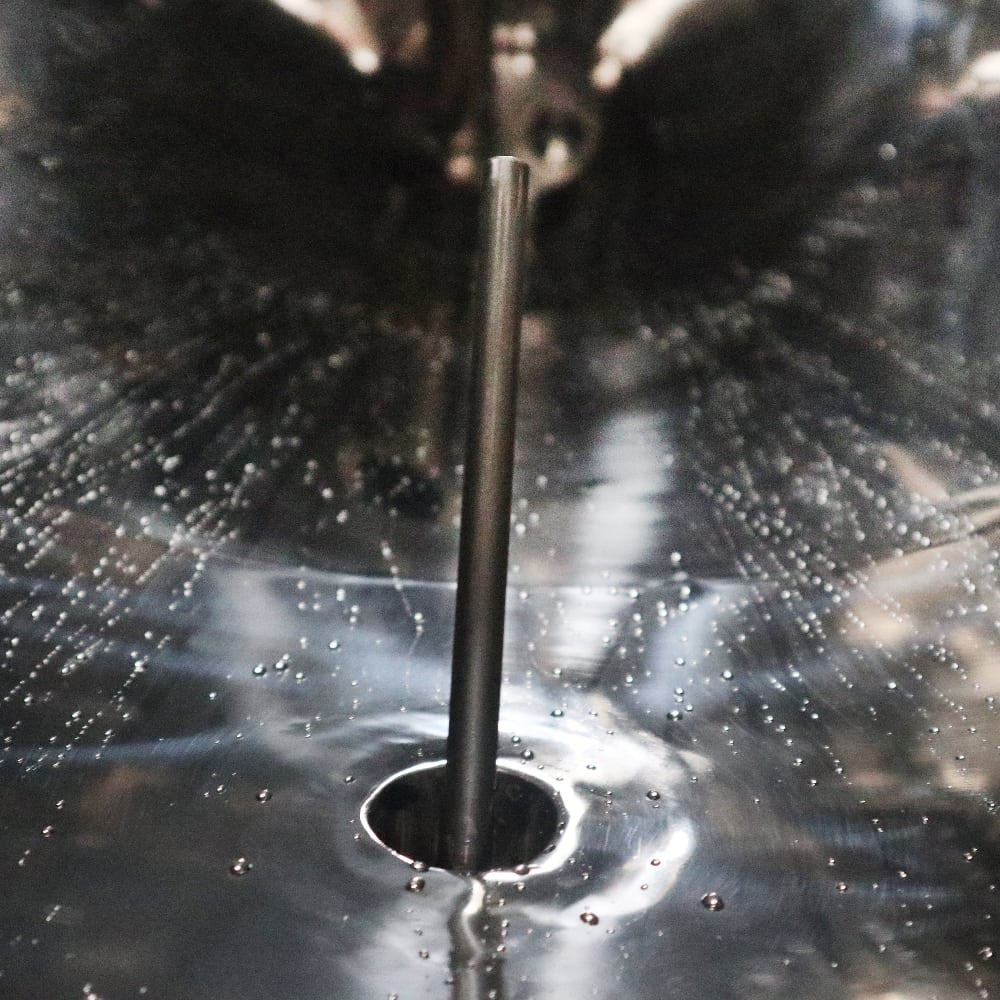 En metallgjenstand med hull, tilsvarende de i PMG 5000L Unitank av rustfritt stål, isolert og fullt utstyrt (Bestillingsvare) som brukes til fermentering.