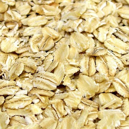 Nærbilde av Flaket Havre (Havregryn) - 100G fra Stangeland Mølle, med sin flate, ovale form og bleke, gylne farge - ideell til baking eller ølbrygging.