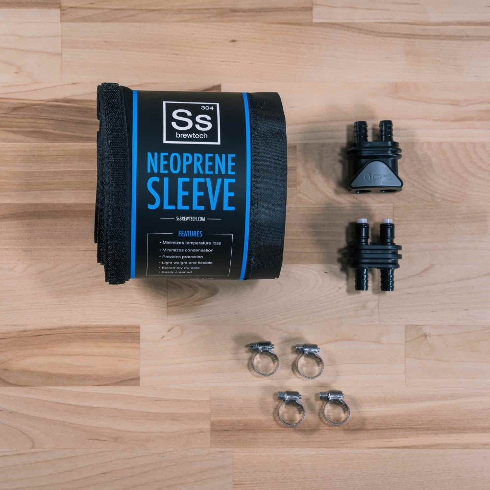 Ss Brewtech FTSS One Quick Disconnect Kit, som består av en neoprenhylse, to svarte plastfittings og fire slangeklemmer i metall, vises sammen med emballasjen på en treflate.