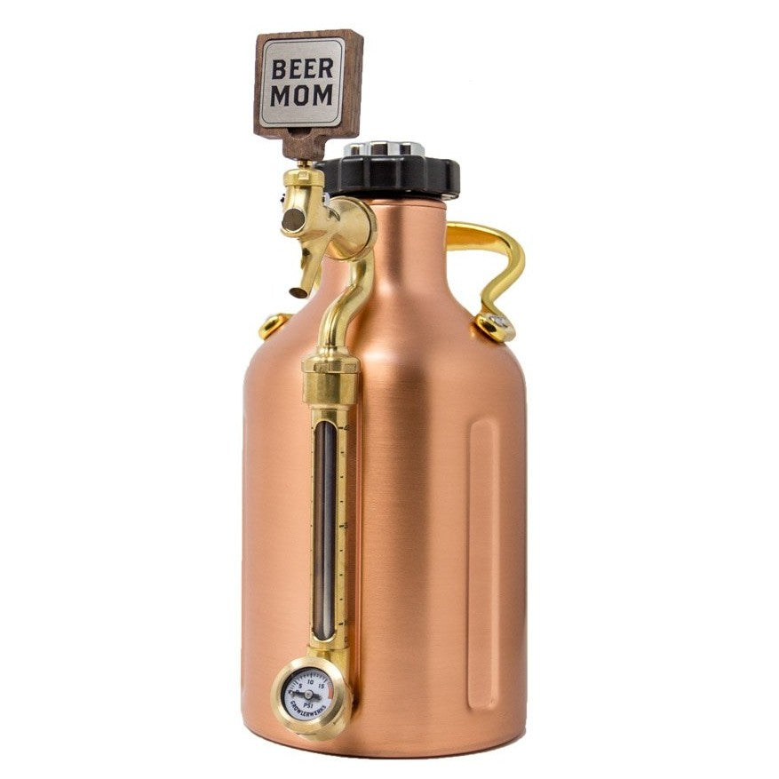 GrowlerWerks Beer Mom Tap Handle for uKeg er en ølbrumler i kobber med trykkmåler, kran og Beer Mom-skilt på toppen, trygt pakket i en skumbelagt eske for beskyttelse.
