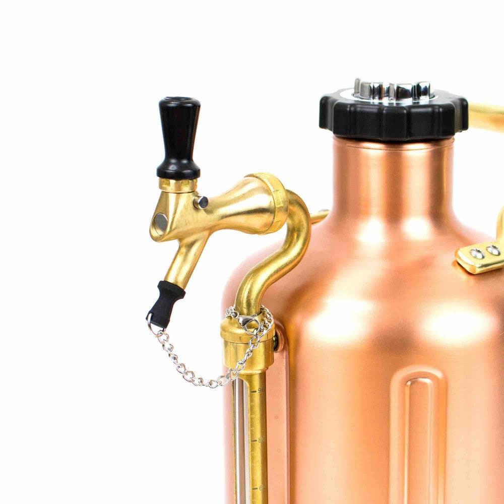 Nærbilde av GrowlerWerks uKeg Tap Plug, en kobberfarget metallsprøyte med svart dyse, messingbeslag og håndtak festet med kjetting, med næringsmiddelsgodkjent gummi for trygg bruk i næringsmiddelindustrien.