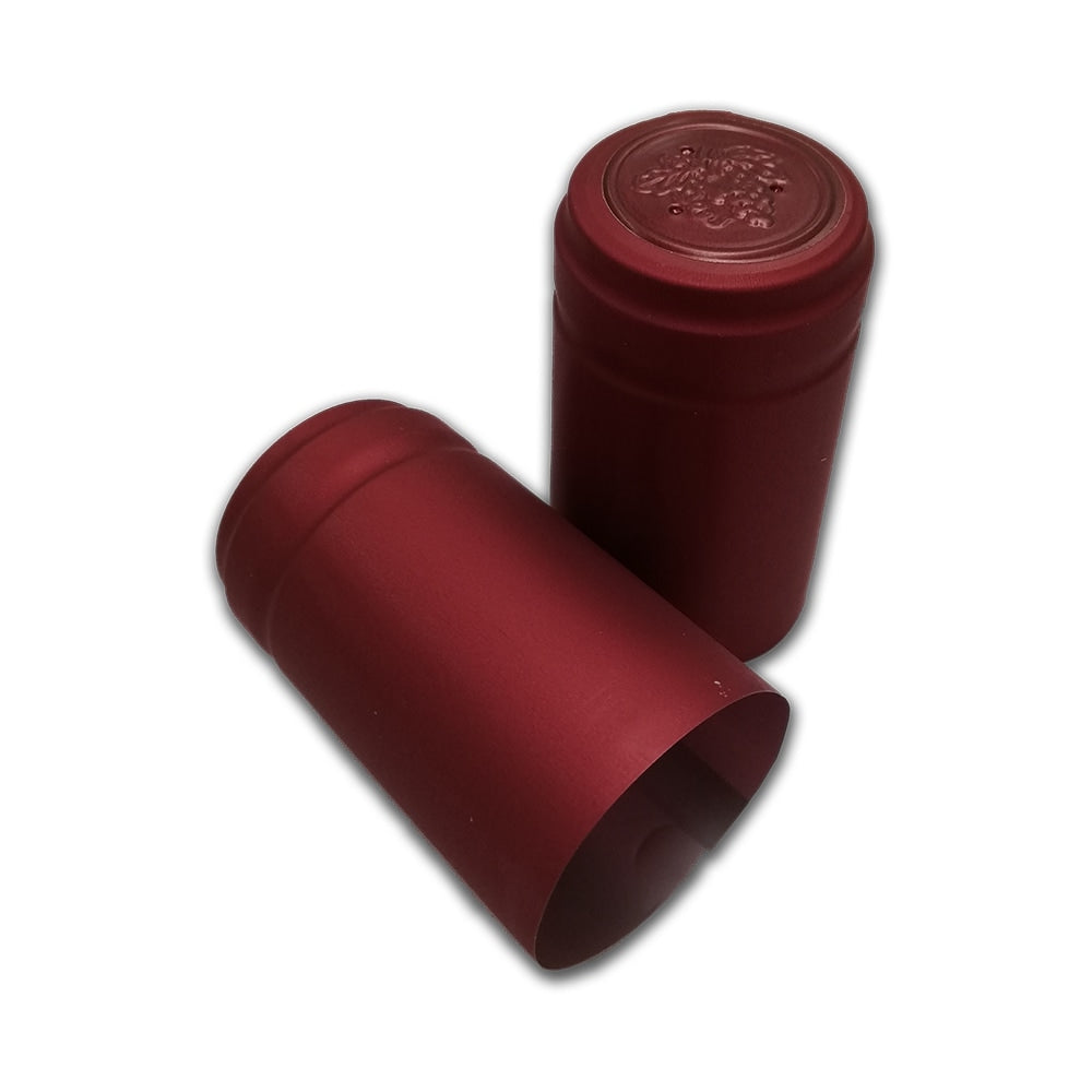 To "Røde krympehetter til vinflasker - 30stk" fra Handcraft Supplies: den ene står oppreist med preget topp, den andre ligger på siden, begge vist mot hvit bakgrunn.