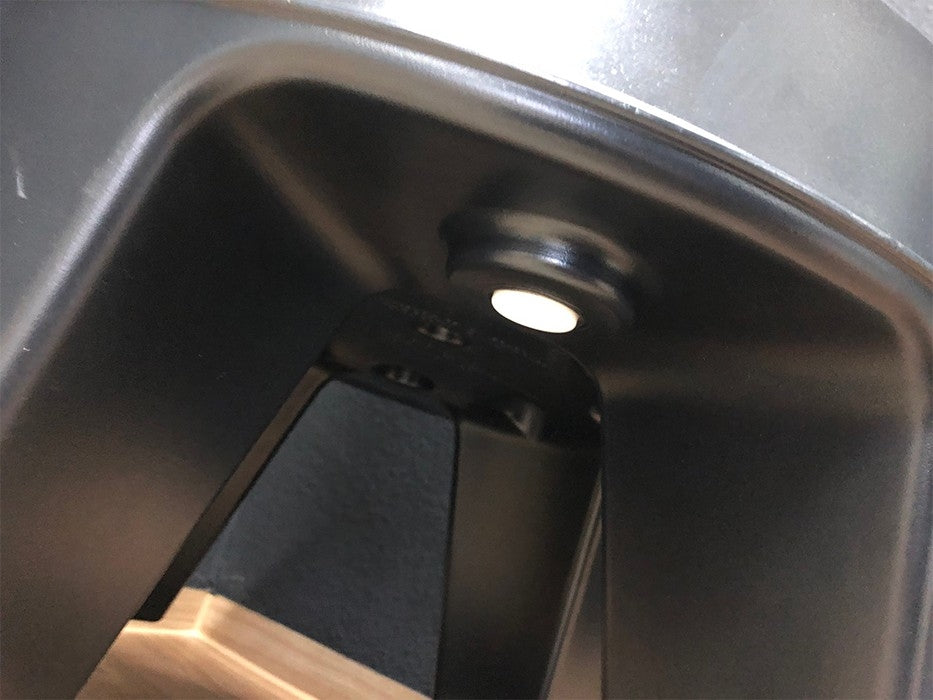 Nærbilde av undersiden av en svart plastkrakk, med Speidel Base med hjul til Speidel Braumeister 20L-festepunktet der setet møter bena.