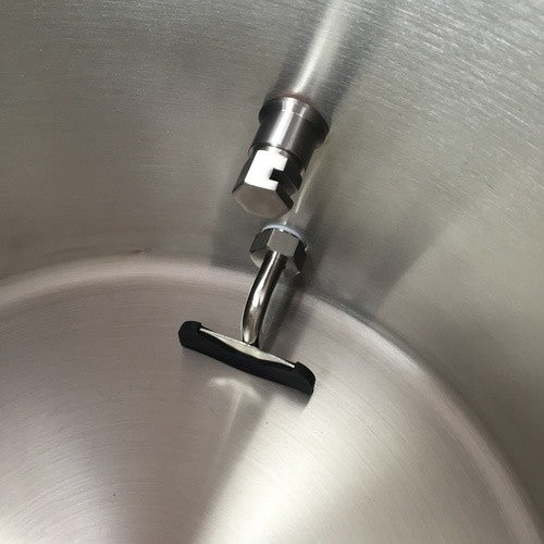 Nærbilde av en Ss Brewtech Whirlpool Fitting med svart håndtak, montert på innsiden av en bryggekjele i rustfritt stål 304 fra Ss Brewtech nær den nederste sideveggen.