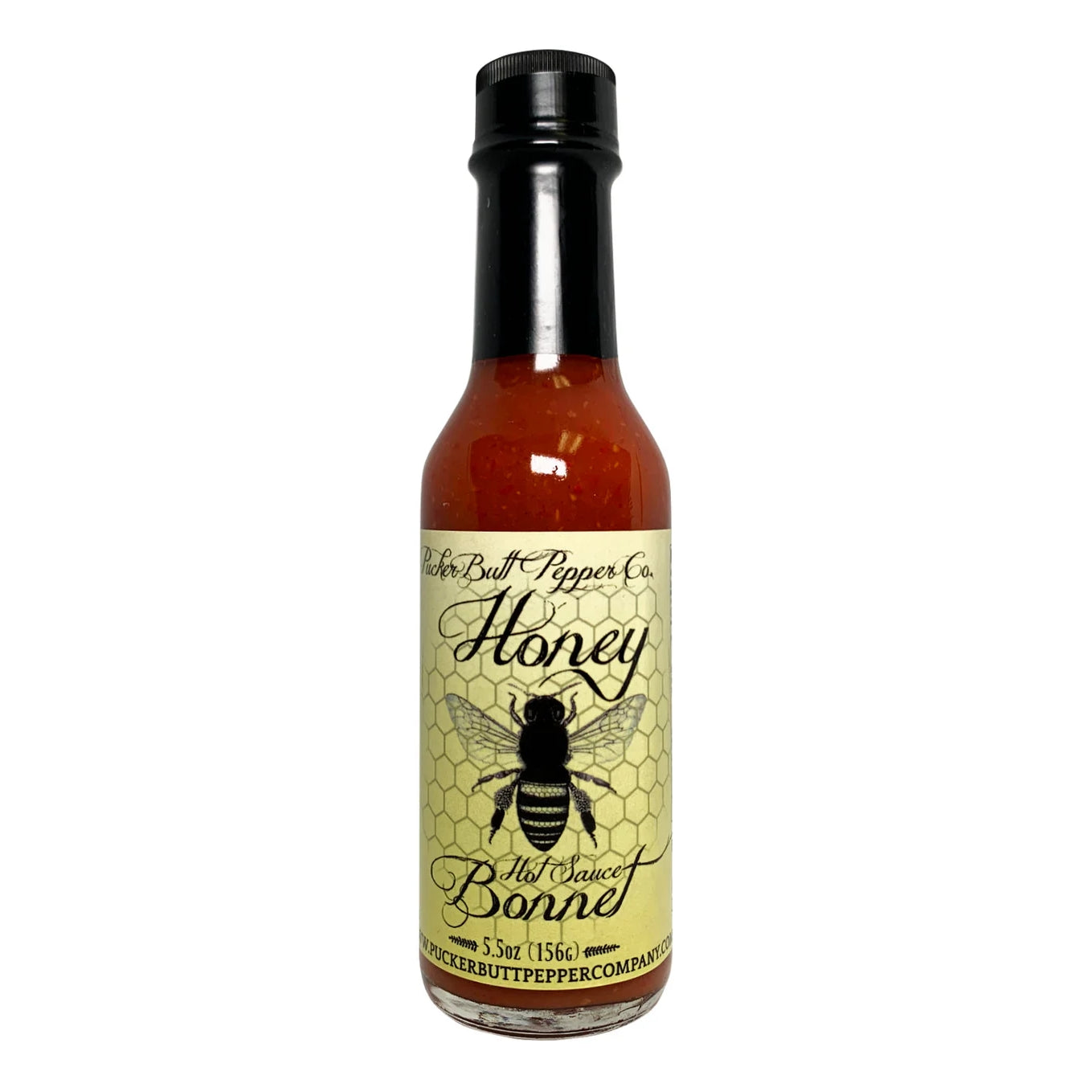 En flaske PuckerButt Pepper Company Honey Bonnet hot saus har en bie på en gul etikett og blander søt honning med brennende hete for det perfekte krydrede kicket.
