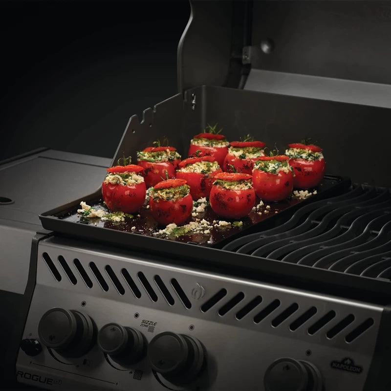 Fylte tomater med urter og ost er anrettet i en grillpanne på Napoleon Stekeplate, smal, klar til å tilberedes på gassgrillen.