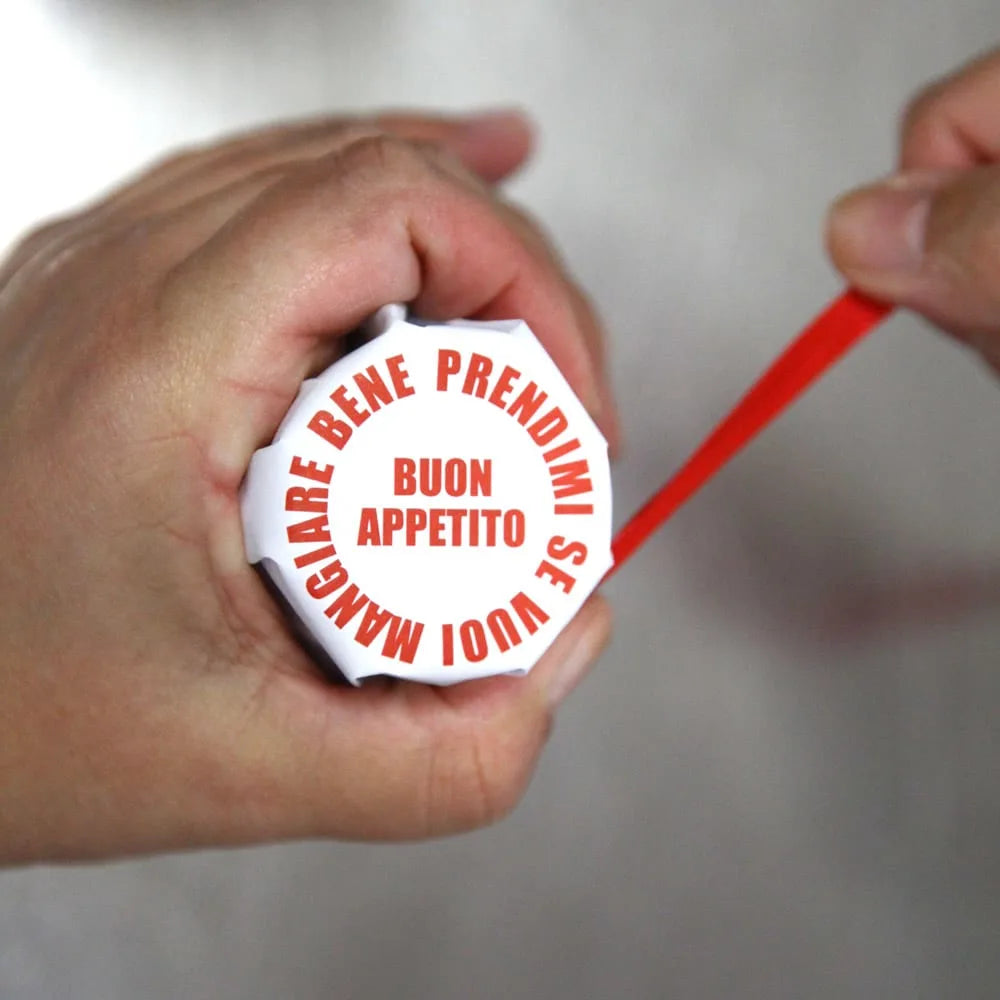 En hånd holder en hvit beholder med Don Antonio Sugo per Pizza 250 ml | Ekte Italiensk pizzasaus med rød tekst på lokket. En annen hånd åpner den med et rødt verktøy - perfekt til hjemmelaget pizza med ekte italiensk pizzasaus.