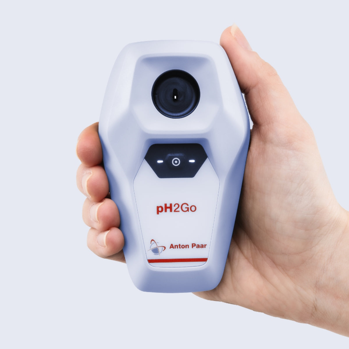 En hånd holder pH2Go Digital pH-måleren – Anton Paar, et kompakt apparat med en ISFET-sensor og indikatorlamper på forsiden for presise pH-målinger.