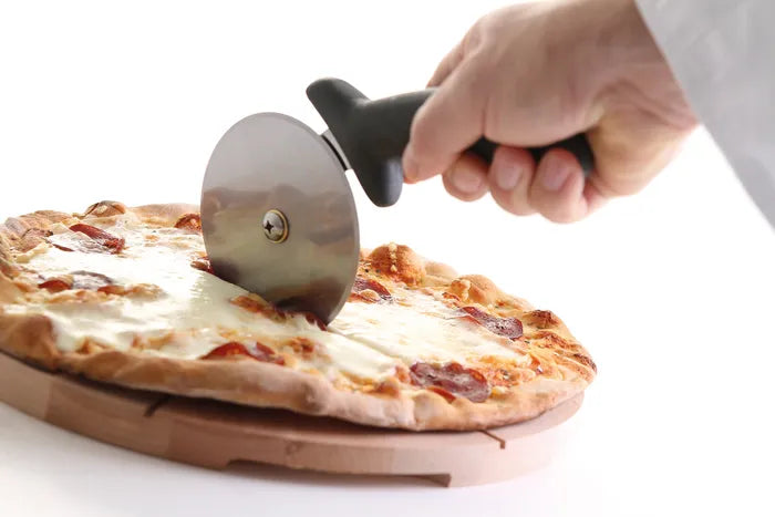 En hånd skjærer en pepperonipizza på et trebrett mot en hvit bakgrunn ved hjelp av Hendi Pizza Slicer / Pizzahjul.
