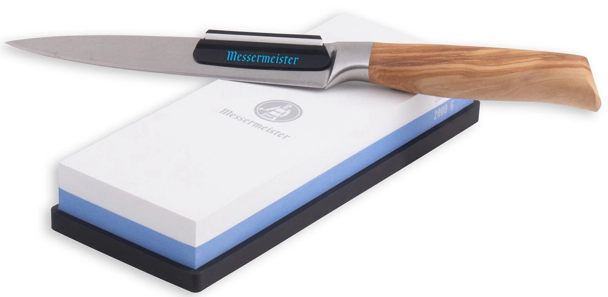 En kjøkkenkniv med trehåndtak hviler på Messermeister Slipestein 2000 & 5000 Grit, ideelt for presis knivsliping.