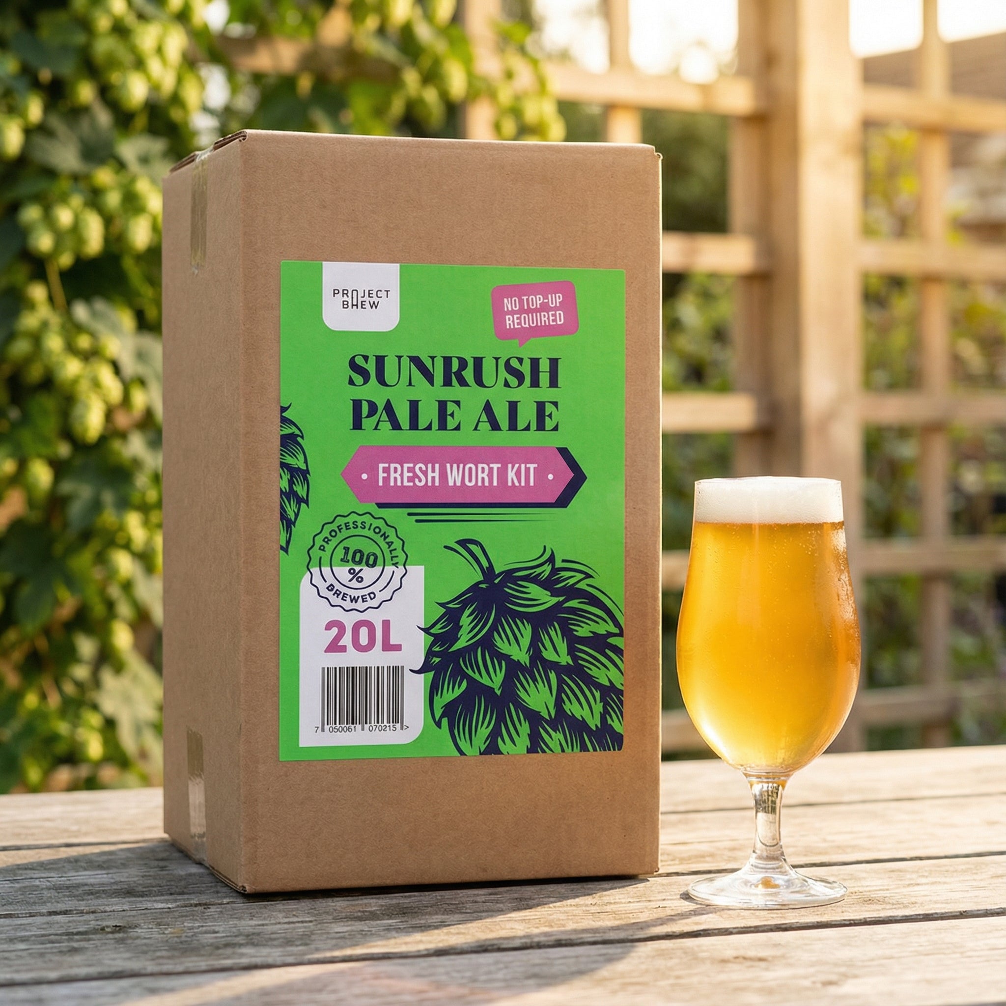 En Project Brew Sunrush Pale Ale - 20L Fresh Wort Kit-eske og et glass pale ale brygget med Ebbegarden Kveik står på et utendørs trebord, omgitt av grøntområder og et plankegjerde.