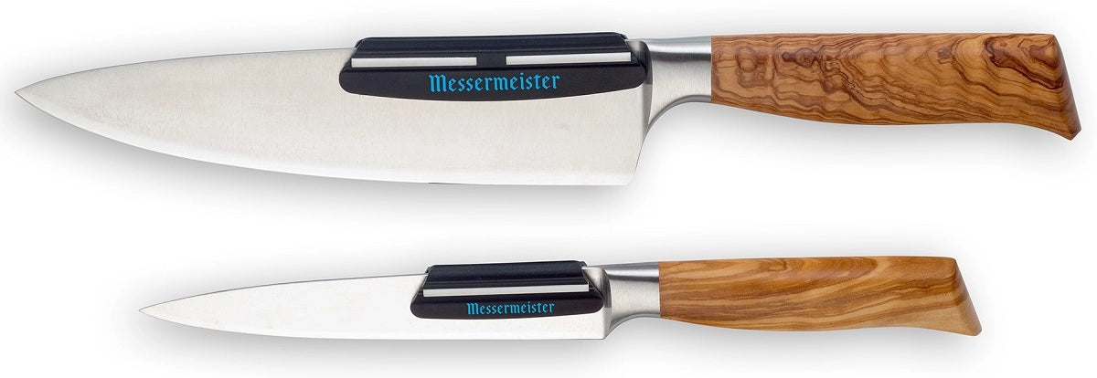 To Messermeister kjøkkenkniver med trehåndtak og bladbeskyttere, en stor og en liten, ligger side om side. Ideell for presise kutt - spesielt når den brukes sammen med Messermeister Vinkelguide For Kniv Sliping-slipeguiden.