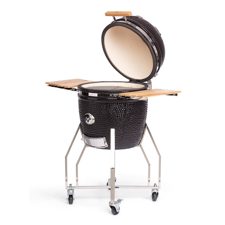 YAKINIKU Kamado Large Complete er en svart keramisk grill med hengslet lokk, sidehyller, innebygd termometer og et robust metallstativ med hjul.
