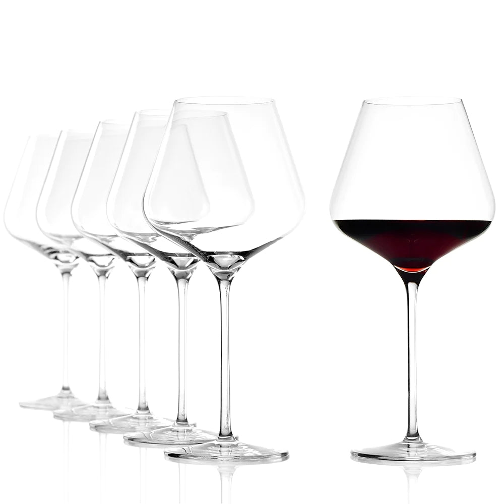 Seks QUATROPHIL Burgunder vinglass 710 ml fra Stölzle Lausits er stilt opp mot en hvit bakgrunn, fem tomme og det lengst til høyre elegant fylt med rødvin.