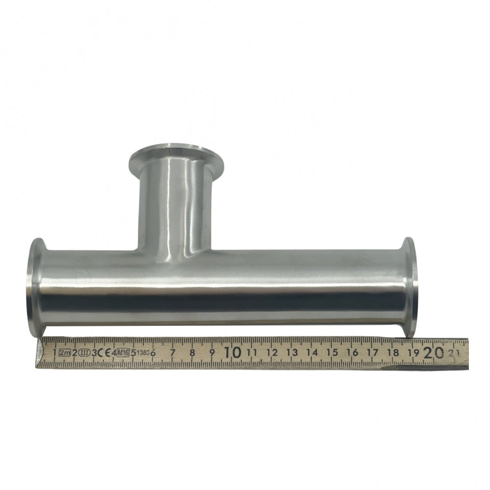 Brewshops spesialtilpassede 1,5" Tri-Clamp T-adapter (5 + 10 cm), laget av 304 rustfritt stål, er vist over en linjal som måler ca. 20 centimeter i lengde.