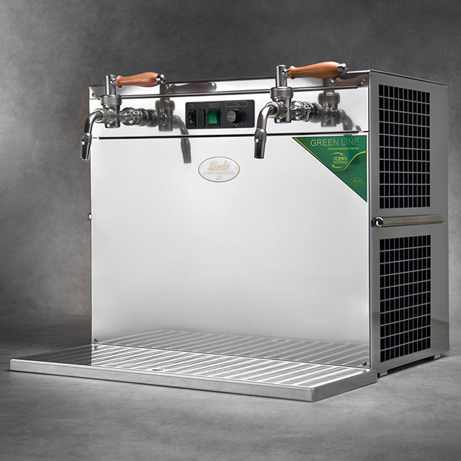 Lindr KONTAKT 300 Twin Power Green Line fra Lindr er en fatøldispenser i rustfritt stål med to kraner, trehåndtak, dryppbrett og ventilasjonsgitter, vist mot en grå bakgrunn.
