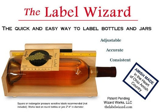 En flaske plasseres i Label Wizard - manuell etikettmaskin fra Label Wizard, et justerbart Amish-produsert treverktøy perfekt for hjemmebryggere til å merke flasker og krukker.