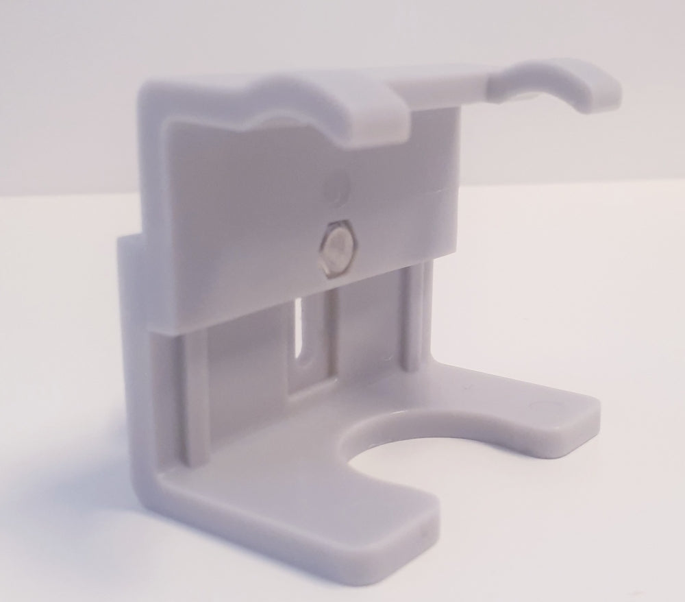 Tapcooler Handsfree Clip fra Tapcooler er en veggmonteringsbrakett i grå plast med en U-formet slisse og skruehull, designet for å holde ølventilens fatkontakt eller Tapcooler mottrykksfyller sikkert mot enhver flat overflate.