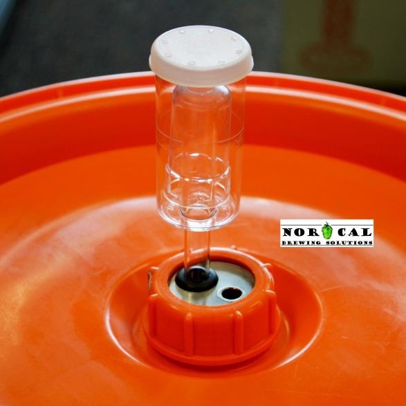 En oransje Speidel Fermenter med Norcal-logo har en luftsluse i plast og Norcal Termobrønn (termobrønn) montert i lokket.