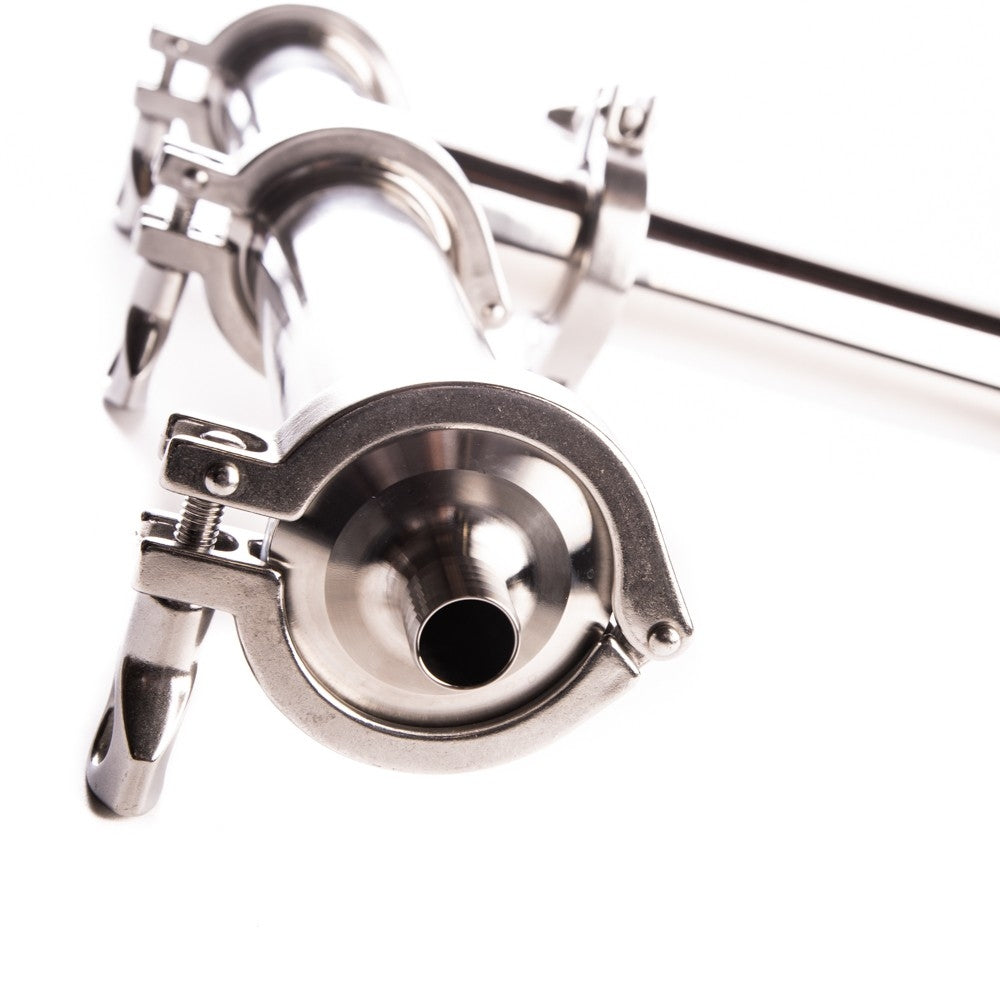 Nærbilde av en Brewtools Dampkondensator i rustfritt stål med tri-clamp-fittings, som vanligvis brukes til ølbrygging eller næringsmiddelprosessering, vist mot en hvit bakgrunn.