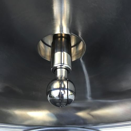 Nærbilde av Brewshop CIP Roterende Vaskeball 3" TC x 1/2" NPT, laget av 304 rustfritt stål, montert i taket på en industriell vask eller oppvaskmaskin.